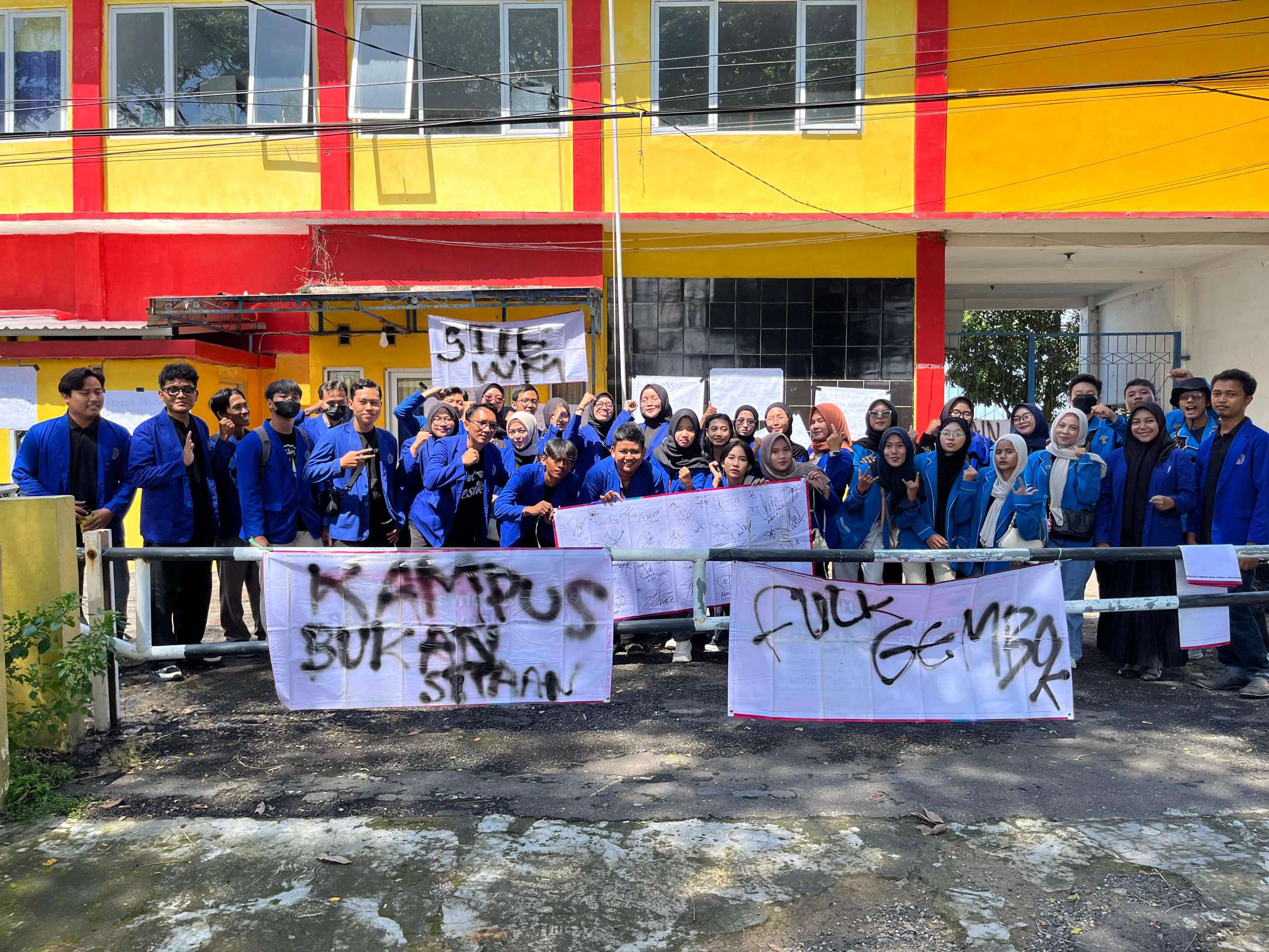 Mahasiswa STIE Widya Manggalia Brebes berkumpul di depan gerbang kampus yang digembok.